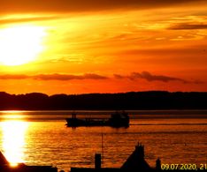 schöner Sonnenuntergang mit kleinem Frachtschiff 