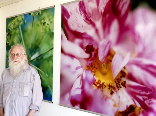 Helmut Neumann vor seinen Blütenbildern